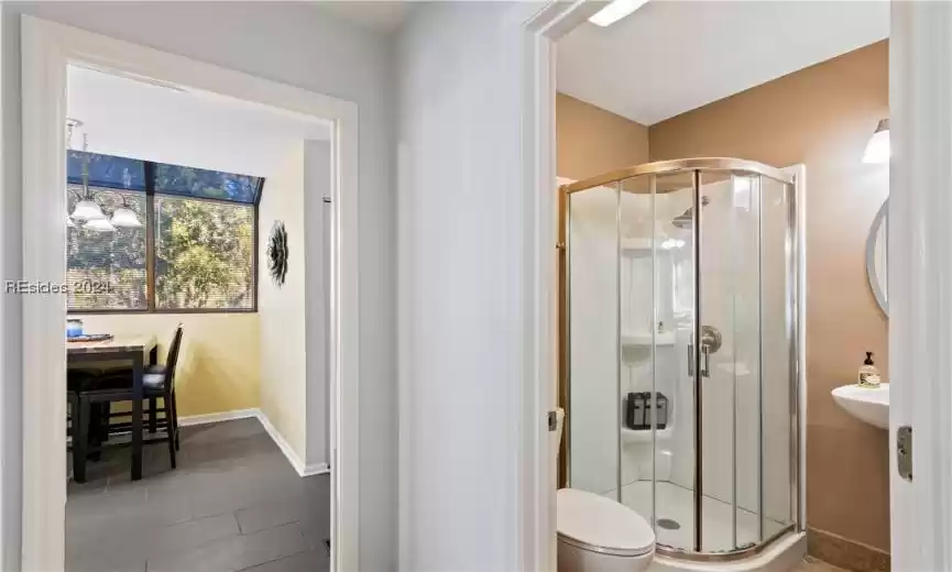 Bathroom with a shower with door, tile flooring, and toilet