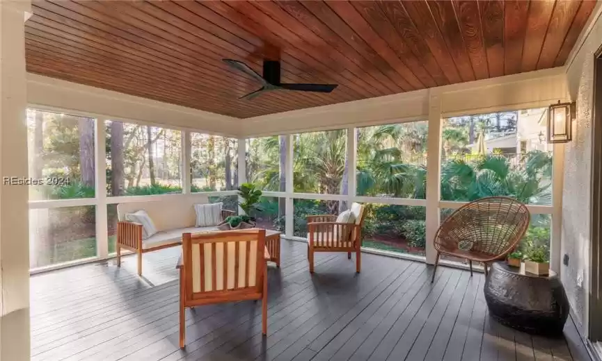Sunroom with wood ceiling, a wealth of natural light, and ceiling fan