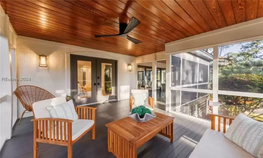 Sunroom / solarium featuring wooden ceiling, ceiling fan, and french doors
