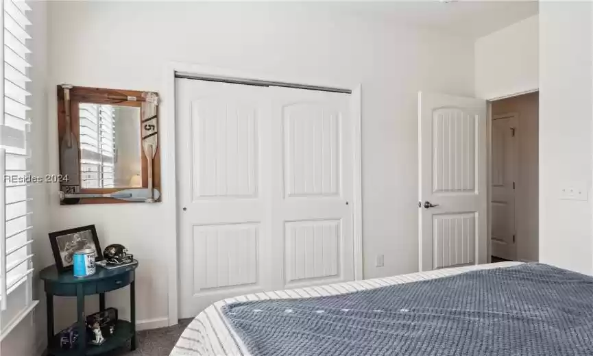 Carpeted bedroom with a closet