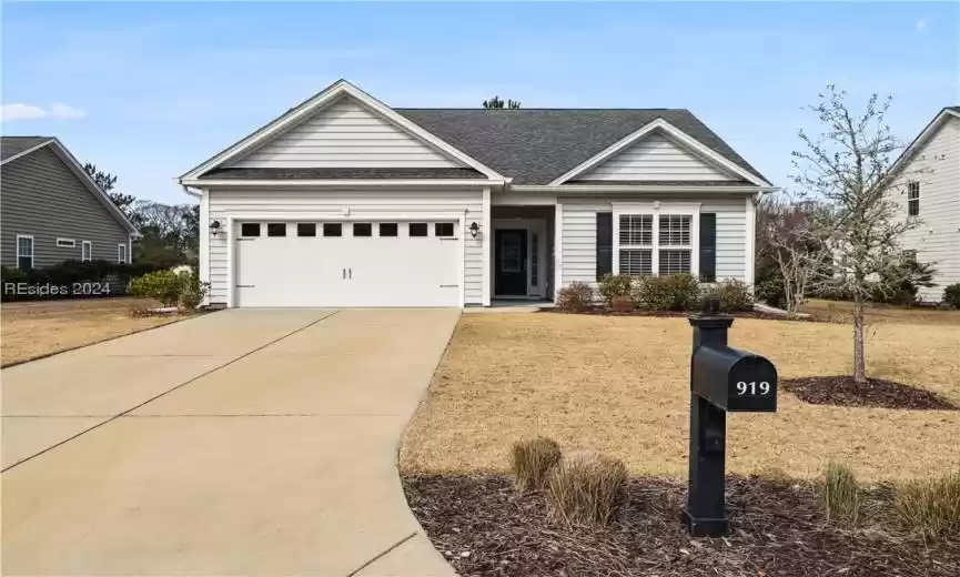 View of front of home featuring a front lawn and a garage