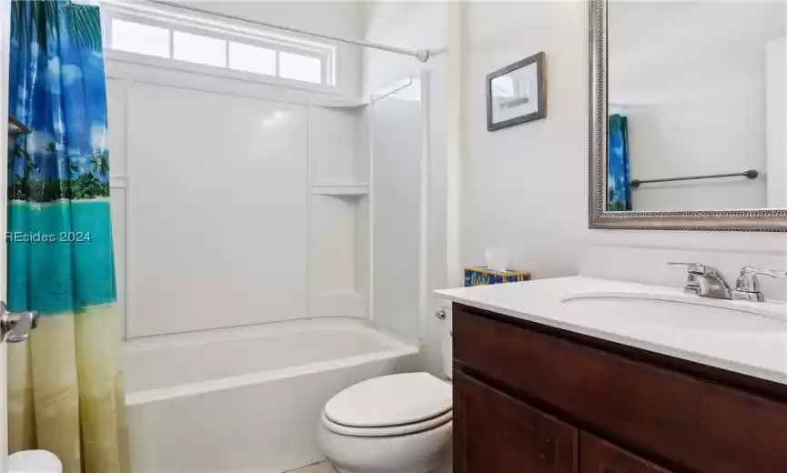 Full bathroom with shower / tub combo with curtain, vanity, and toilet