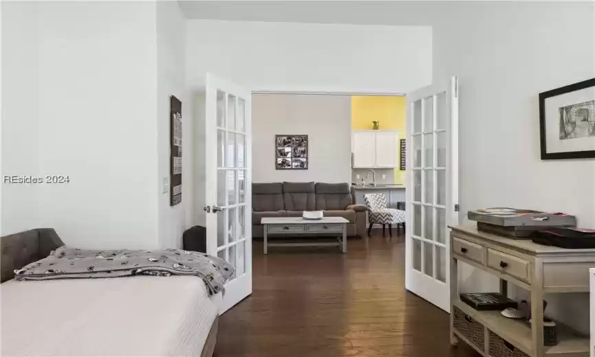 Bedroom with dark hardwood / wood-style flooring, sink, and french doors