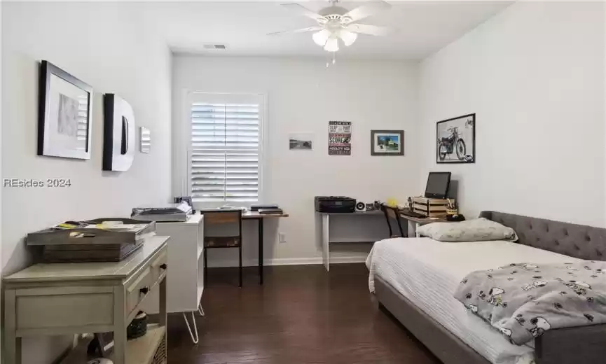 Bedroom with dark hardwood / wood-style floors and ceiling fan