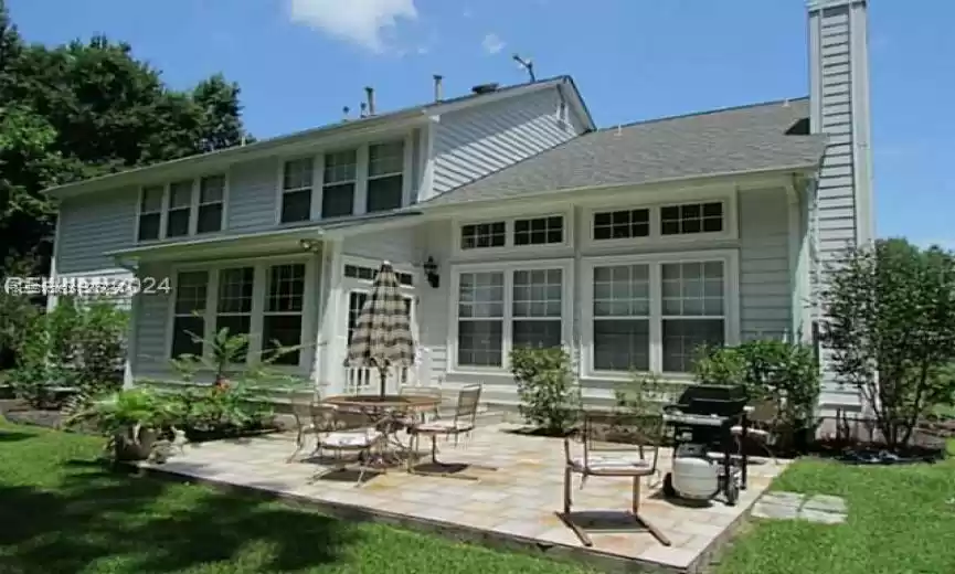 Rear view of property featuring a lawn and a patio area
