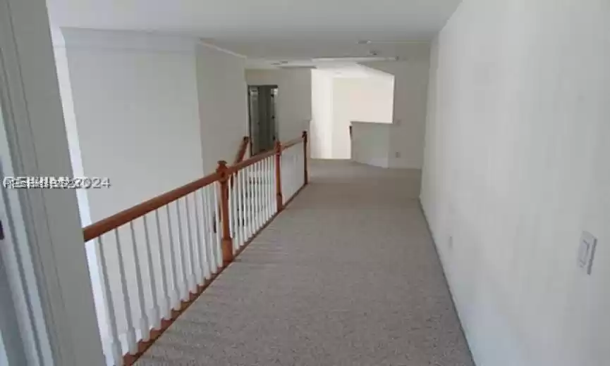 Corridor with light colored carpet