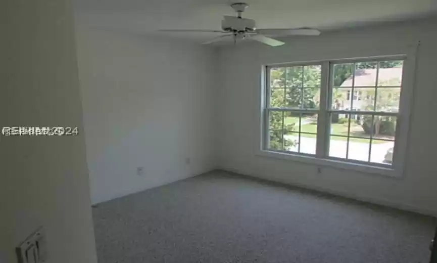 Spare room with ceiling fan and carpet flooring