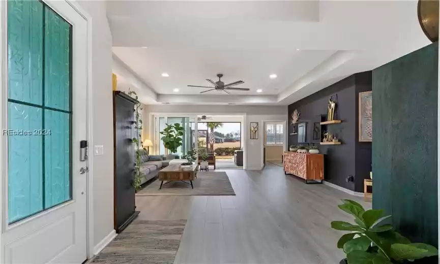 Foyer with hardwood / wood-style flooring, a tray ceiling, and ceiling fan