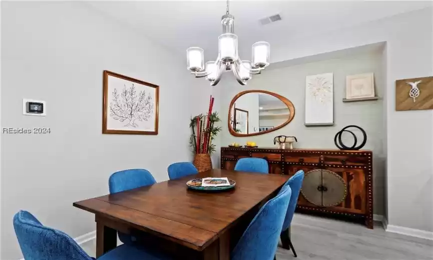 Dining space featuring light hardwood / wood-style flooring and a notable chandelier