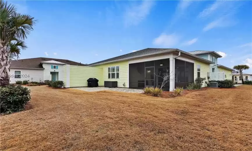 Rear view of house featuring a sunroom and central AC unit