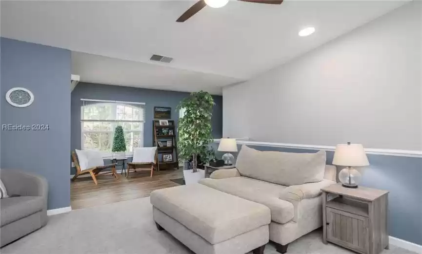 Living room featuring light hardwood / wood-style floors and ceiling fan