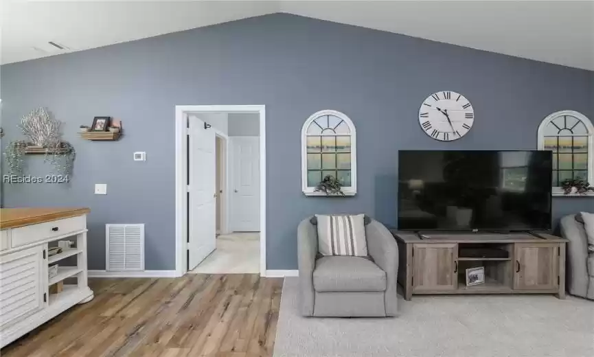 Sitting room with light carpet and lofted ceiling