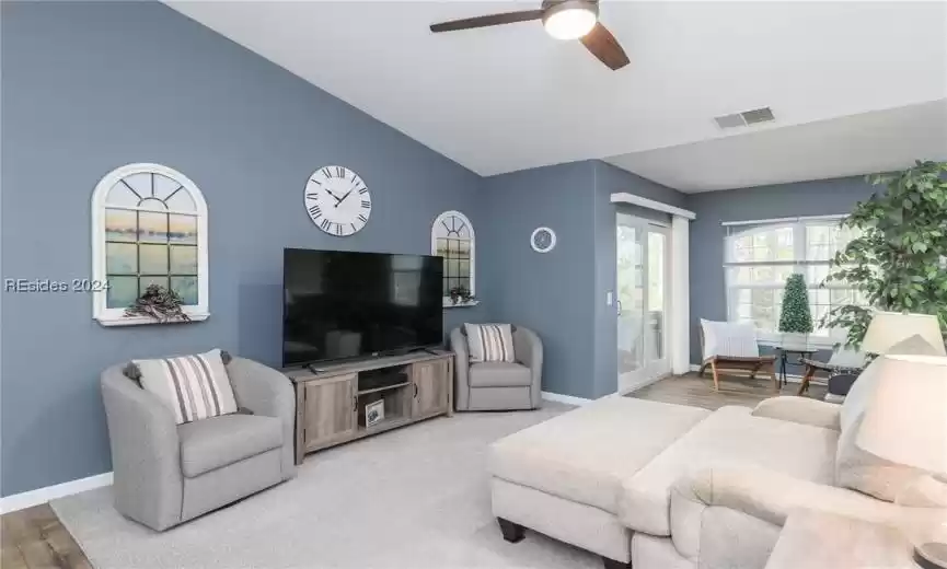 Living room featuring light hardwood / wood-style flooring, lofted ceiling, and ceiling​​‌​​​​‌​​‌‌​‌‌​​​‌‌​‌​‌​‌​​​‌​​ fan