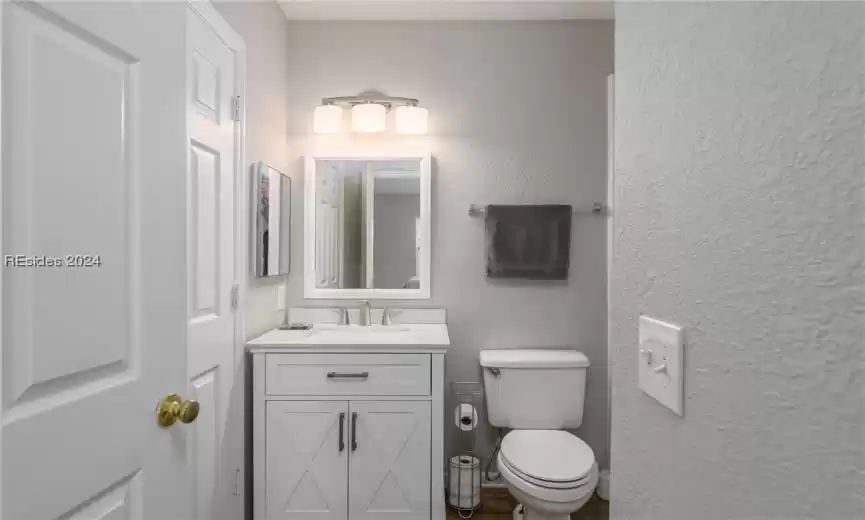 Bathroom featuring hardwood / wood-style flooring, large vanity, and toilet