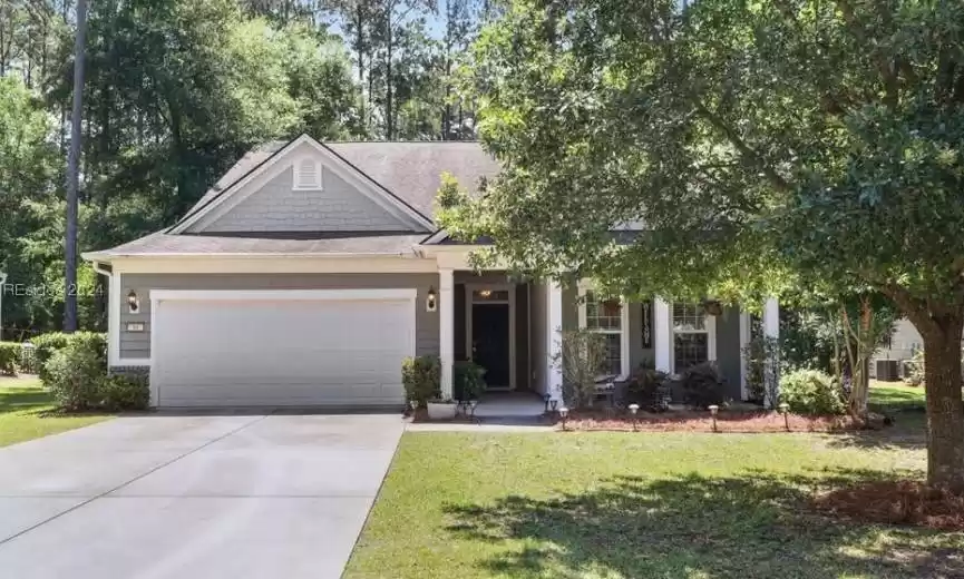 View of front of home with a front yard and a garage