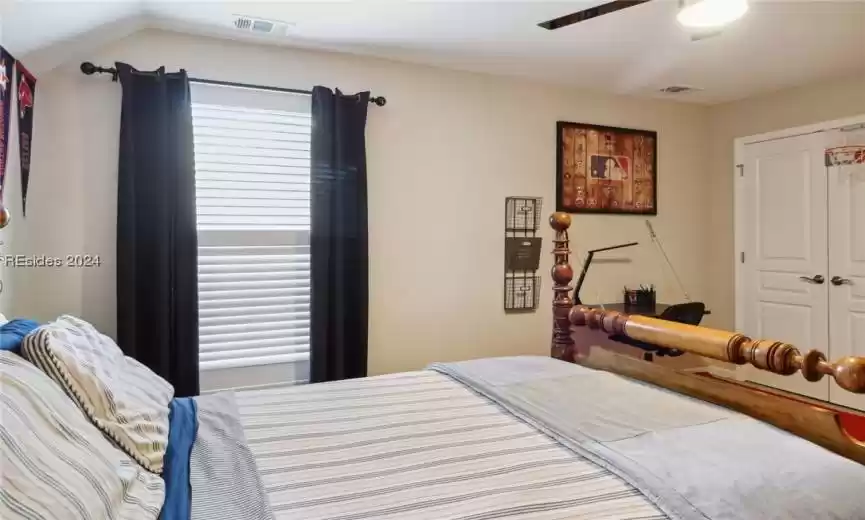 Bedroom featuring a closet, ceiling fan, and lofted ceiling