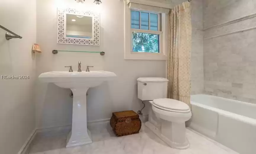 Full bathroom with shower/bath combination and tile floors.