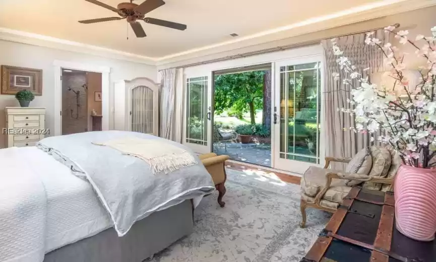 Bedroom with ensuite bathroom, access to exterior, ornamental molding, ceiling fan, and heartpine floors.