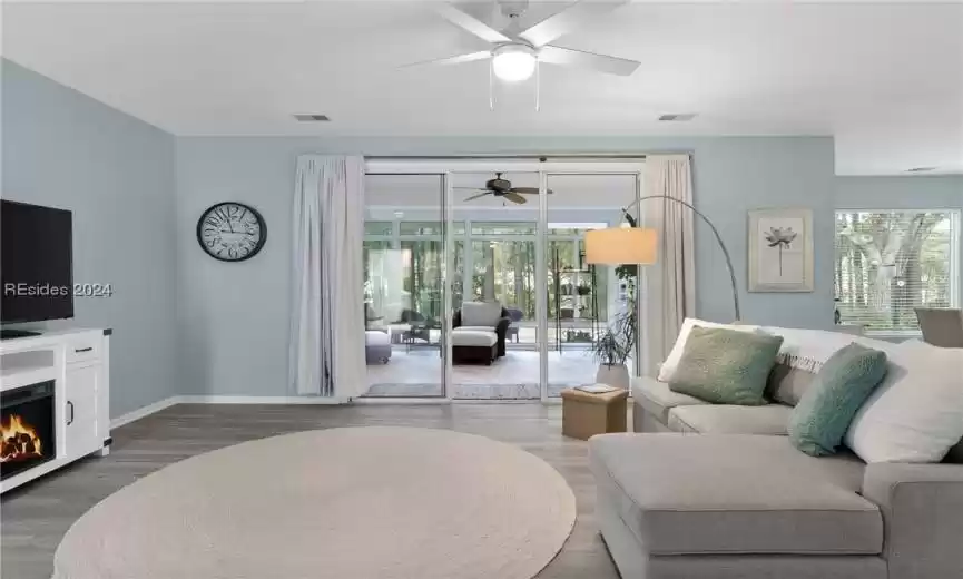 Living room with a wealth of natural light, ceiling fan, and dark hardwood / wood-style floors