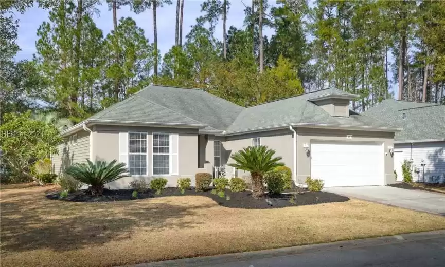 View of front of property with a front yard and a garage