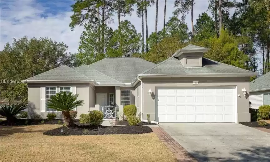 View of front of property featuring a front yard and a garage