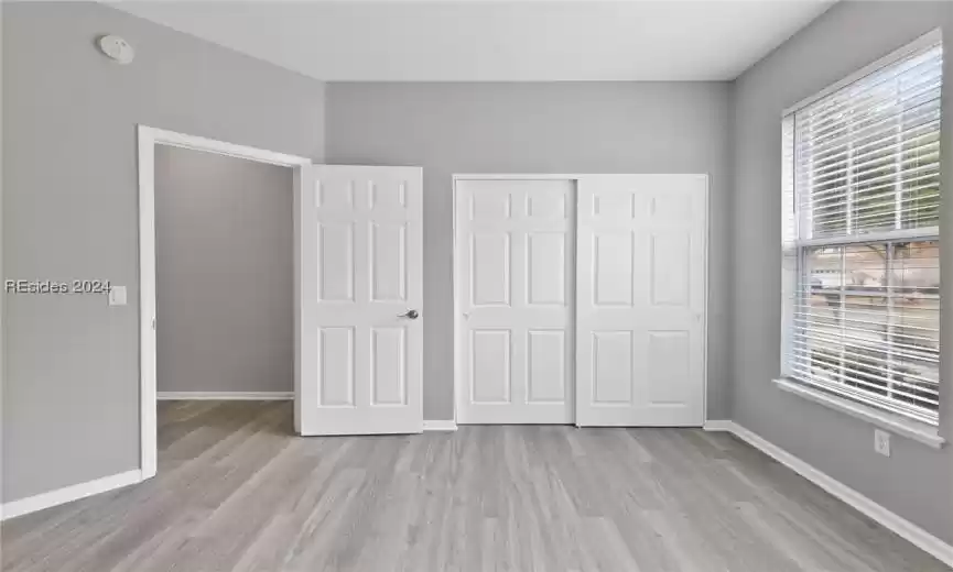 Unfurnished bedroom featuring light wood-type flooring and a closet