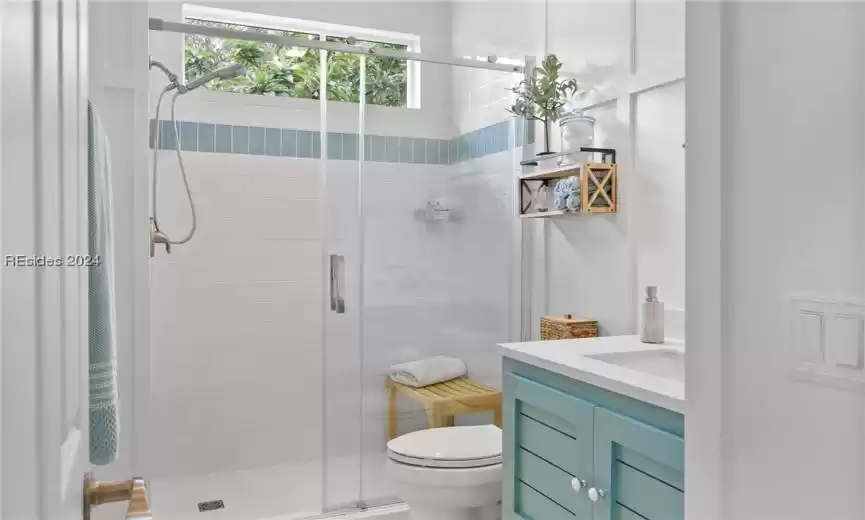 Bathroom with vanity, toilet, and a shower with door