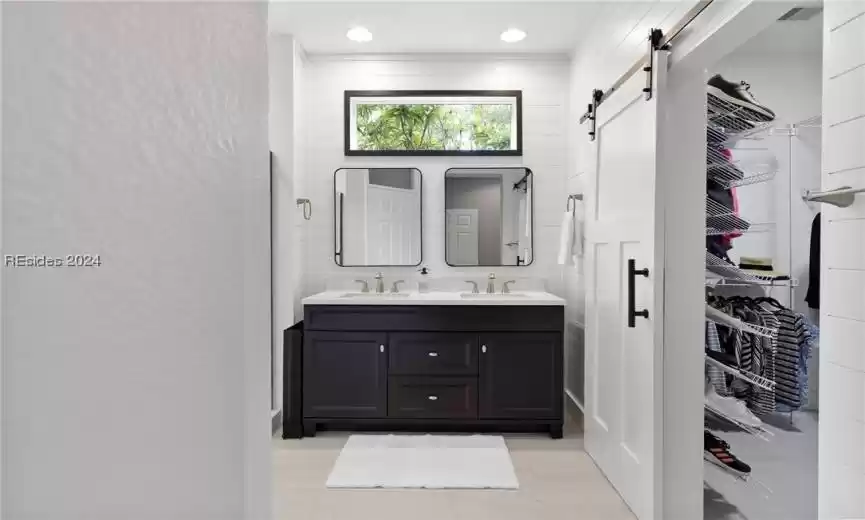 Bathroom featuring dual vanity, tile walls, and tile floors