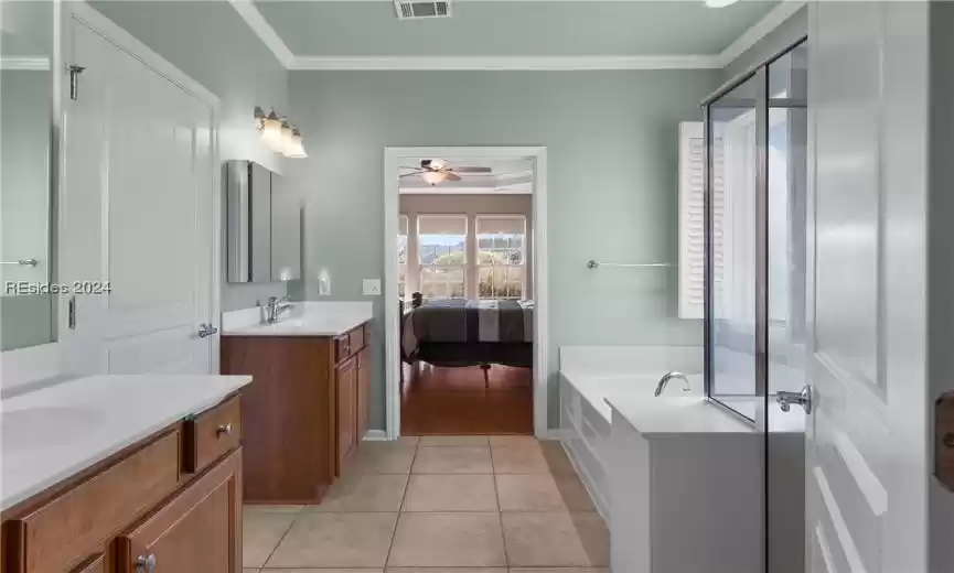 Bathroom featuring a bathtub, tile floors, ceiling fan, and ornamental molding