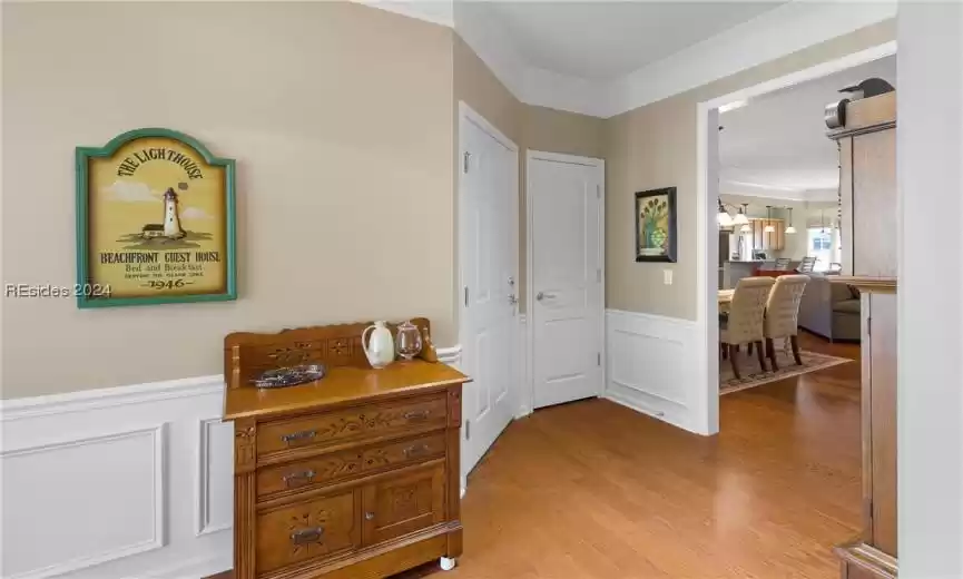 Foyer entrance with an inviting chandelier, light hardwood / wood-style floors, and crown molding