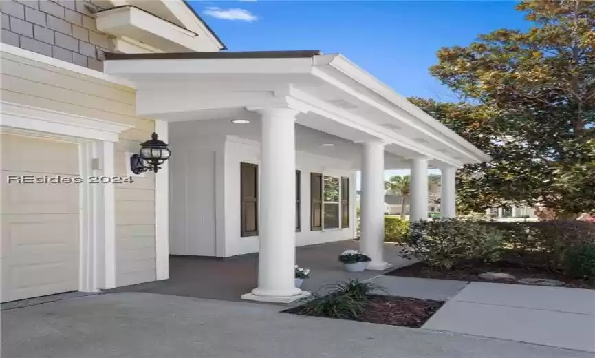 View of exterior entry with a garage and covered porch