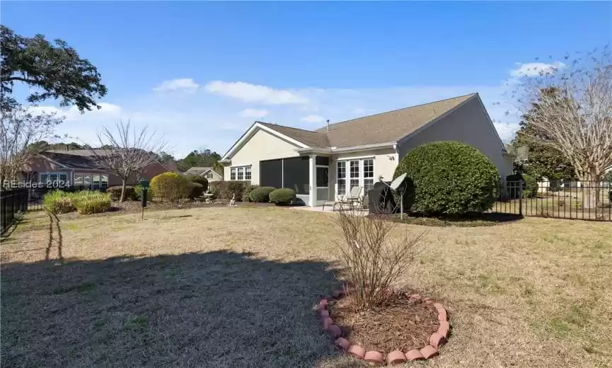 Rear view of house featuring a lawn and a patio