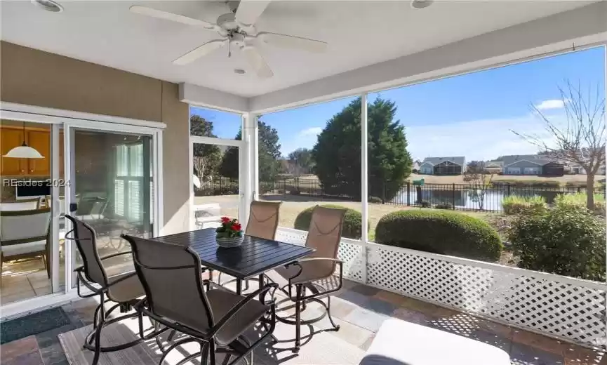 Sunroom featuring a water view and ceiling fan