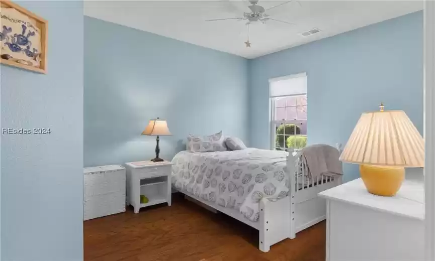 Bedroom with dark hardwood / wood-style flooring and ceiling fan