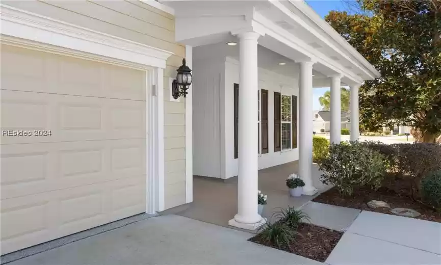 Property entrance with a garage and a porch