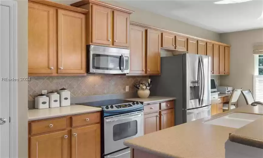 Kitchen with sink, stainless steel appliances, and tasteful backsplash