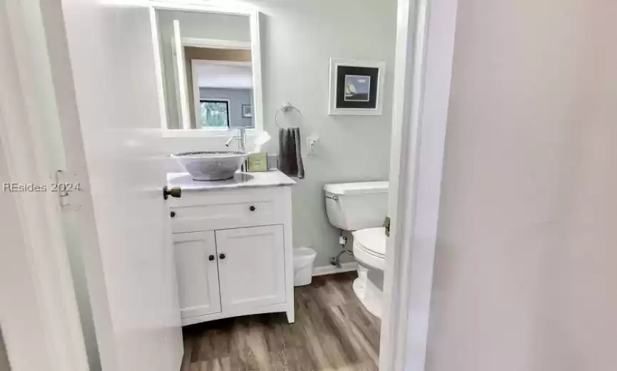 Bathroom with oversized vanity, toilet, and wood-type flooring