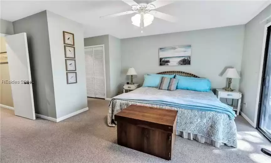 Bedroom featuring a closet, ceiling fan, and light colored carpet