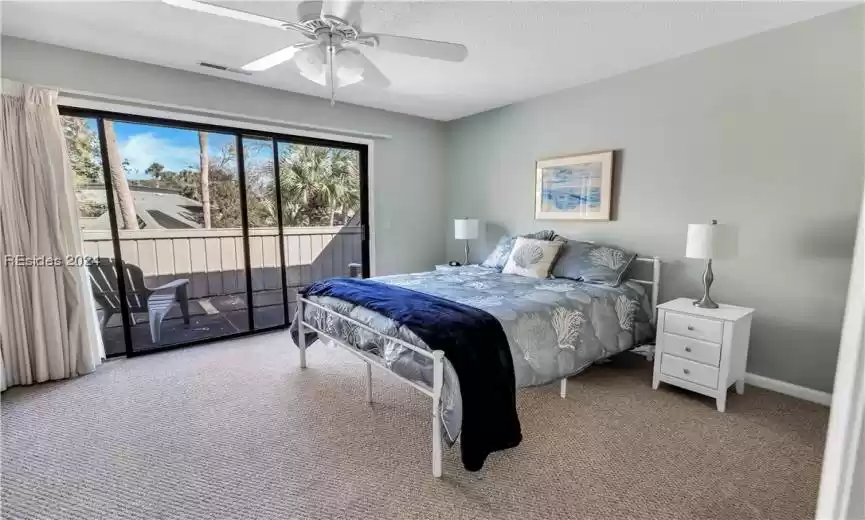 Bedroom with access to outside, ceiling fan, a textured ceiling, and light colored carpet