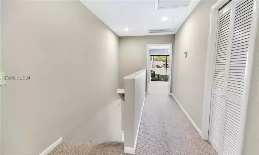 Corridor featuring light carpet