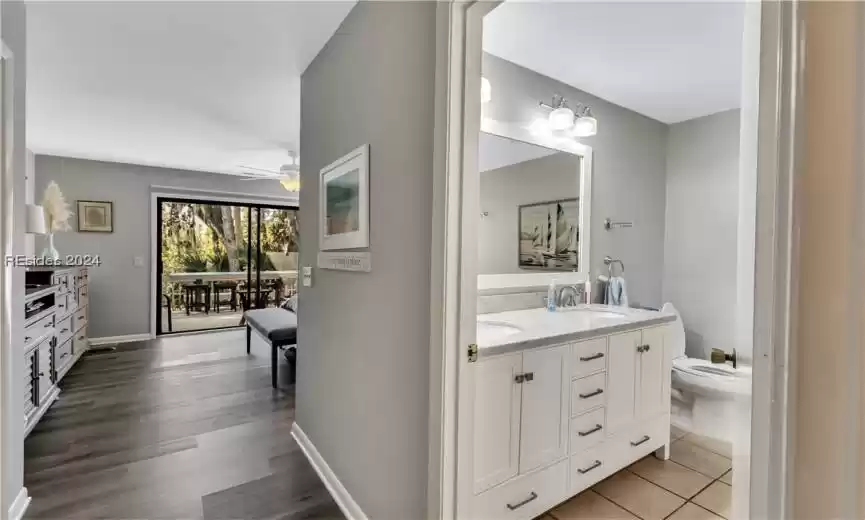 Bathroom featuring hardwood / wood-style flooring, toilet, ceiling fan, oversized vanity, and double sink