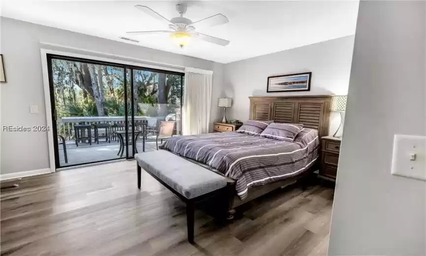 Bedroom with hardwood / wood-style floors, ceiling fan, and access to exterior