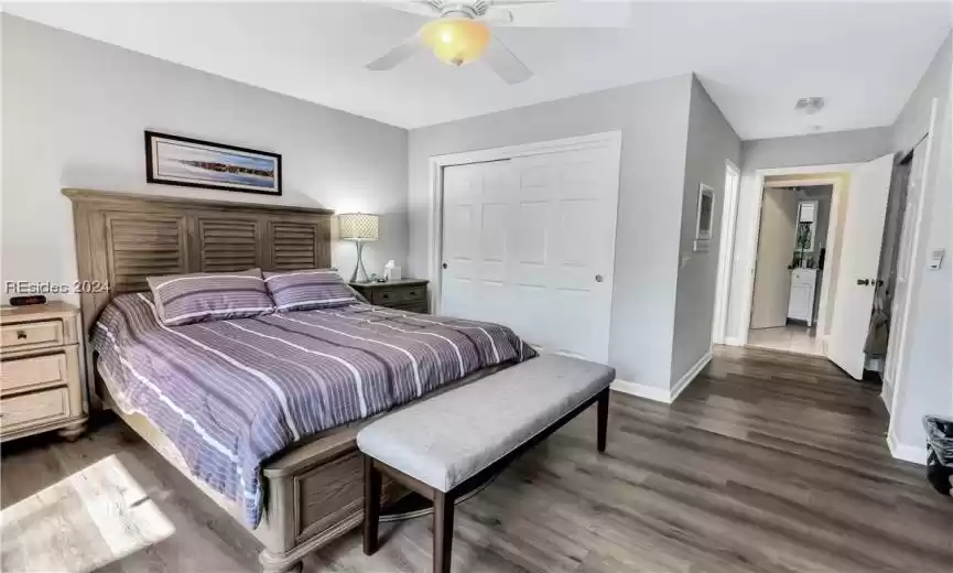 Bedroom featuring dark hardwood / wood-style floors, a closet, and ceiling fan