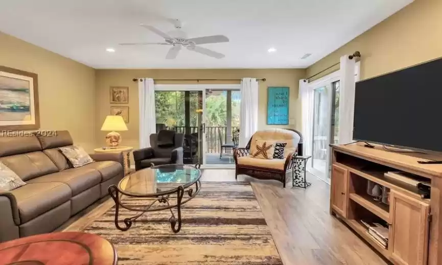 Living room with light hardwood / wood-style floors and ceiling fan