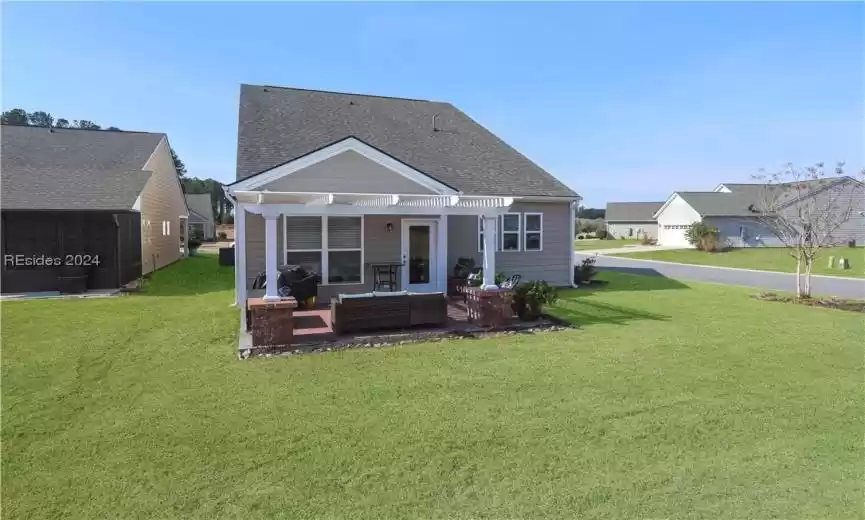 Back of the home showing the Aluminum Pergola and paver patio.