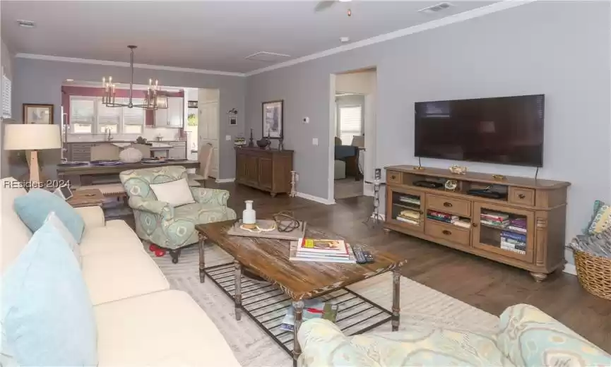 Living room with manufactured wood flooring and crown molding