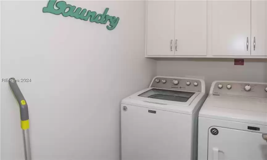 Laundry room with washer and dryer and cabinets is adjacent to the Primary bedroom suite on the first level.