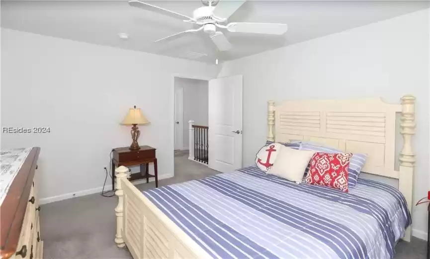 Bedroom featuring carpet, window and ceiling fan has a walk-in closet and another walk-in storage closet at the top of the stairs!