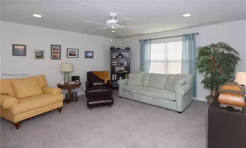 Carpeted living room with ceiling fan and can lights on the bonus room (2nd) level makes this a great place for guests, hobbies, or for a relaxing place for a home theater.
