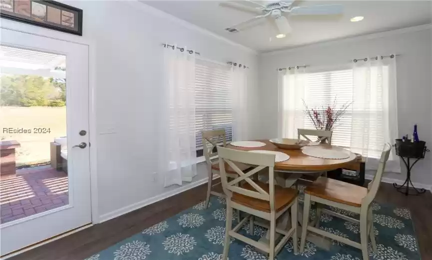 Carolina Room with manufactured wood floors, crown molding, and ceiling fan overlooks the paver patio.